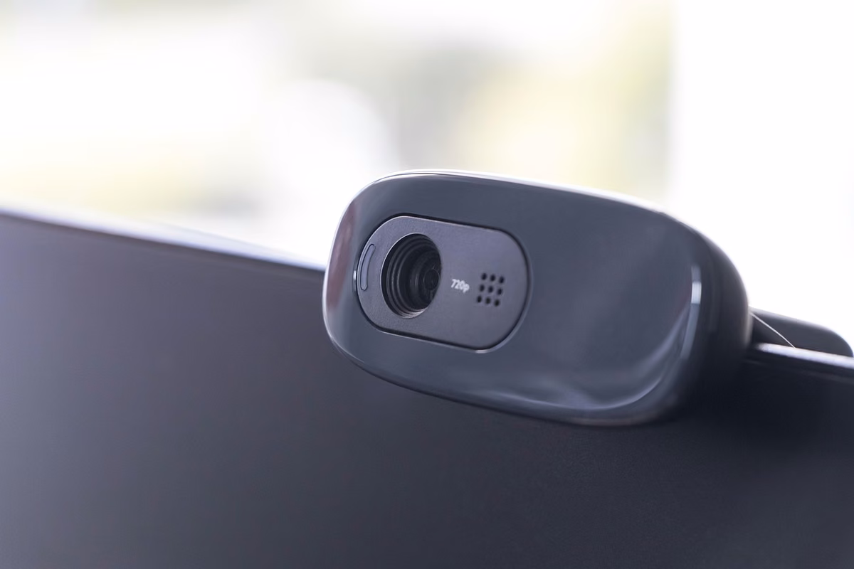 A black webcam clipped to the top of a monitor